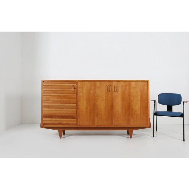 A refined French mid‑century sideboard crafted in cherrywood, circa 1950, showcasing the elegant simplicity and functional...