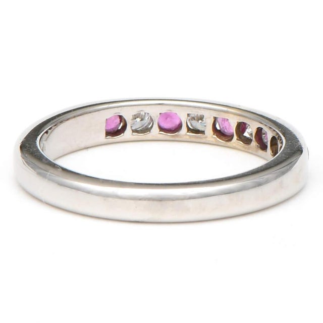 Sleek white gold cradles stunning rubies and breathtaking diamonds in this elaborate channel ring, creating a hidden...