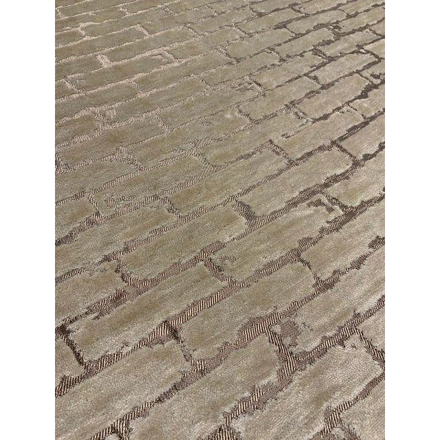 This modern fabric has a metallic bronze base cloth with an ivory cut velvet abstract geometric brick design. It has a...