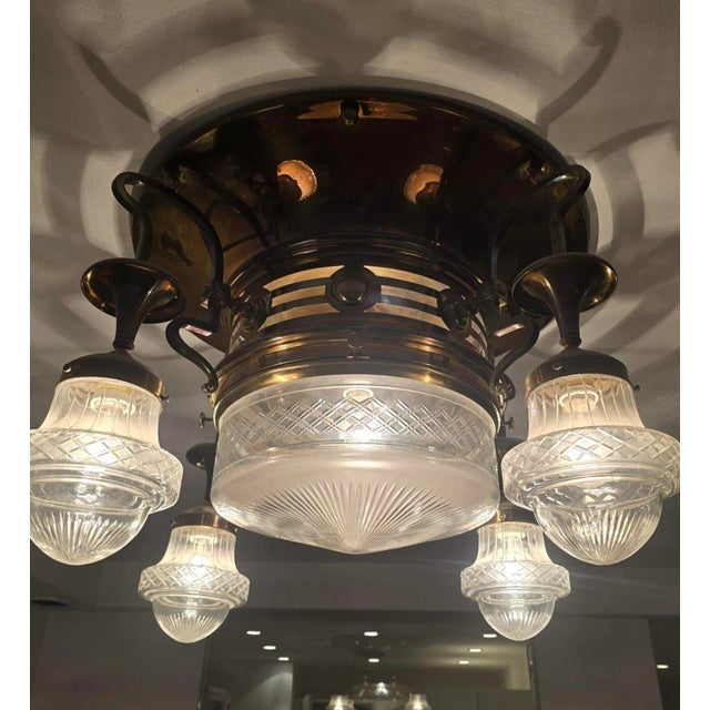 A rare and substantial Art Nouveau flush mount chandelier, dating to circa 1905, executed in solid brass with a refined...