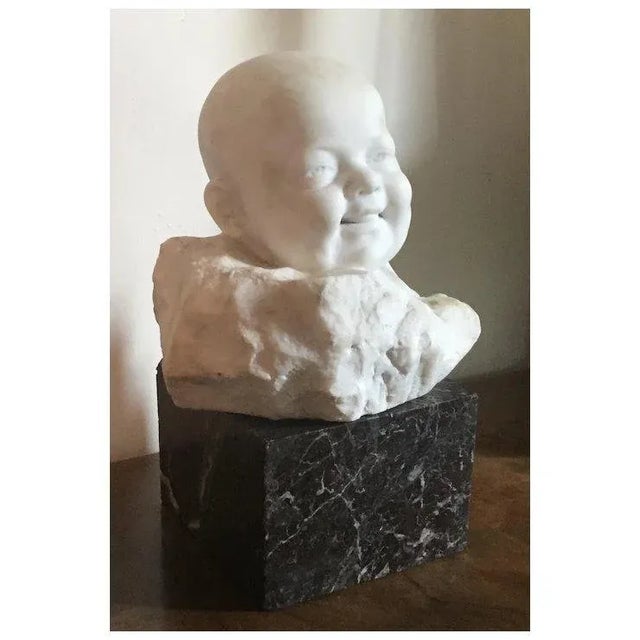 Early 20th century Italian carved white marble bust of an infant signed Giorgio Rossi (1892 - 1968) resting on rouge...