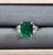 This striking cocktail ring showcases a captivating design centered around a vibrant GIA-certified emerald-cut emerald....