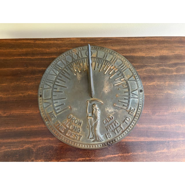 A classic vintage iron garden sundial inspired by traditional English estate landscapes, reading "Grow old along with me....