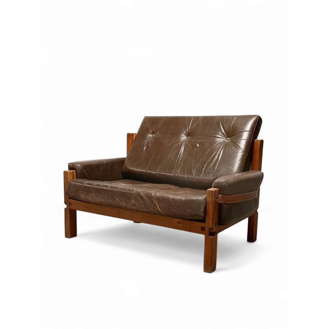 A nice, original love seat by Pierre Chapo. It can be considered as a small sofa or a large armchair. Elm and leather. The...
