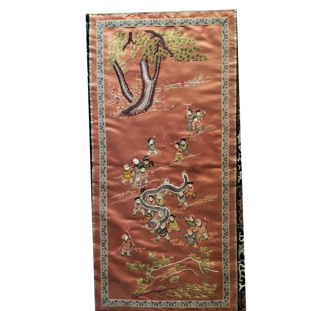 A rare mid-20th century Chinese silk tapestry depicting a lively dragon procession, expertly embroidered with vibrant...
