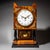 Bracket clock in a walnut case with ebonized columns and base. The case is decorated with brass appliqués. The movement...