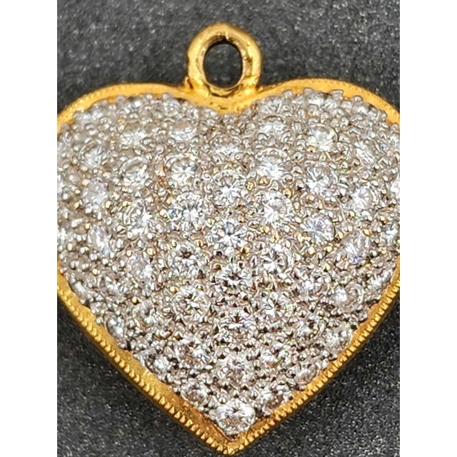 This exquisite pendant necklace features a heart-shaped design adorned with approximately 1.50 carats of round-cut white...