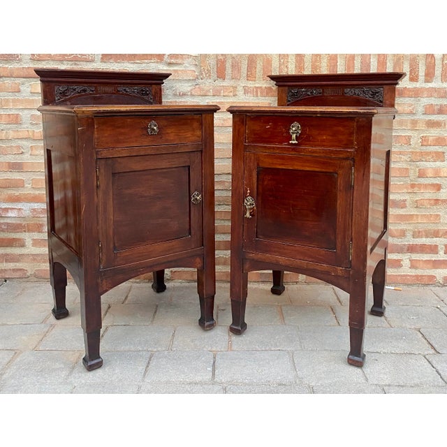 Pair of late 19th century Art Nouveau nightstands with carved tops, bronze handles, restored and wax polished. We observe...