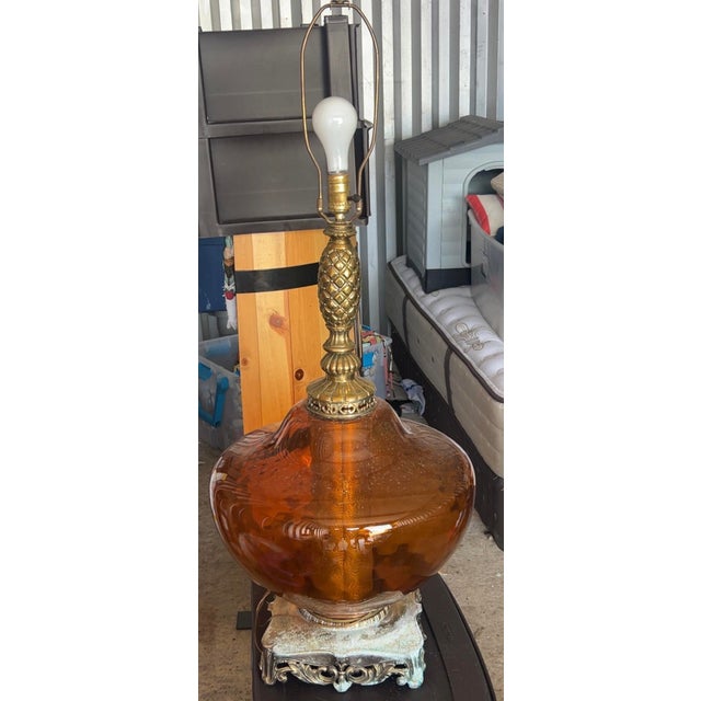 The lamp is designed in the Hollywood Regency style, popular during the mid-20th century. It features a large, hand-blown...