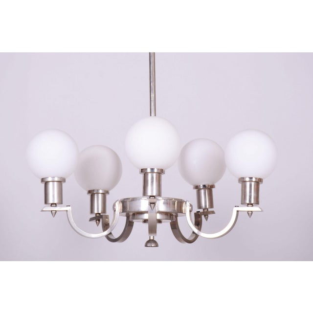 This six-arm pendant chandelier, originating from the 1920s, represents a magnificent and highly representative example of...