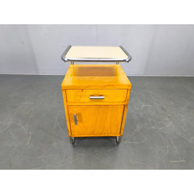 Bauhaus nightstand from 1930s Czechoslovakia featuring a chrome-plated tubular steel frame combined with a wooden cabinet...