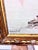This framed maritime oil painting depicts a tranquil harbor scene with fishing boats moored by a pier and a small rowboat...
