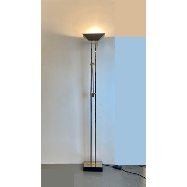 Well-made floor lamp in chromed metal and brass with two dimmable and adjustable light sources. Designed and produced in...