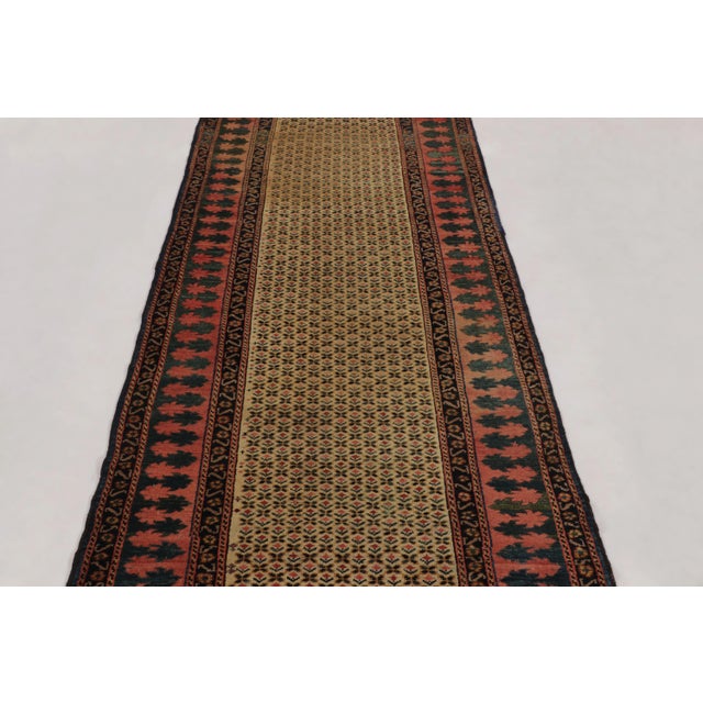 Hand-knotted in wool circa 1890-1900, this 3X9 antique Persian runner rug is a highly decorative piece, distinguished by...