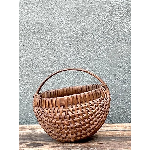 This vintage Shaker-style woven basket presents a pleasingly rounded, swollen silhouette reminiscent of the traditional...