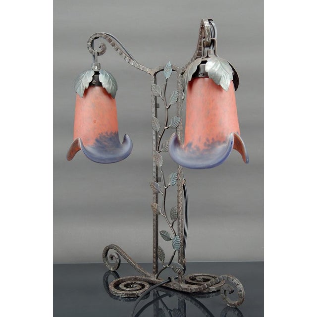 Two-headed lamp in wrought iron by Muller. Art Deco, France, Circa 1920. Floral theme. Wrought iron base depicting a...