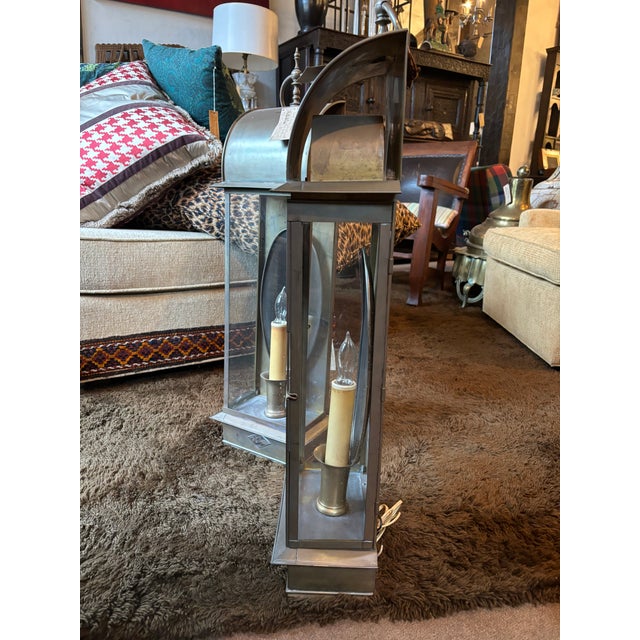 A pair of two lovely antique brass electric wall-mount lanterns. The brass is beautifully preserved. The lanterns feature...