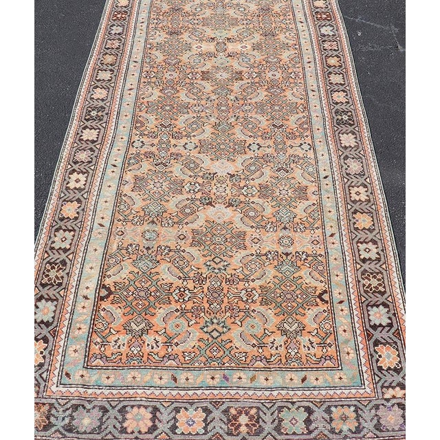 Measures: 3'10"X12'0" Antique Persian Runner in Herati Design With Peach, Teal, and Dark Brown Floral Motifs 3'10"x12'0"...