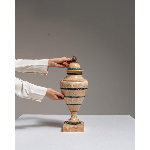 This pedestal makes its impression through pink/tan marble with brass ring accents. Originating in France during 1900s, it...