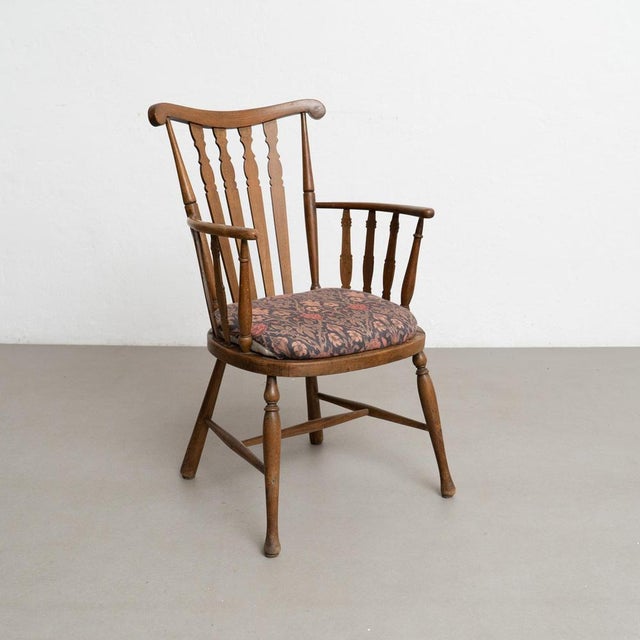 This elegant vintage English wood armchair, dating from circa 1950, showcases timeless craftsmanship and enduring style....
