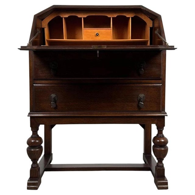 A handsome early 20th-century English bureau, finely crafted from oak and distinguished by its fitted writing interior,...