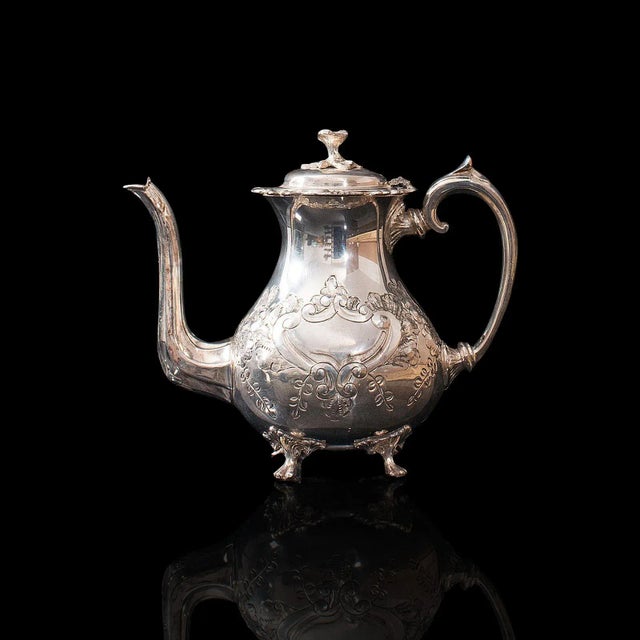 This is an antique tea service. An English, silver plated, hand chased teapot and jug set by John Turton of Sheffield,...