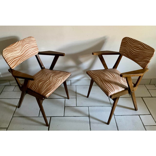 This elegant pair of Mid-Century Modern armchairs was produced in Europe during the 1960s. The chairs feature an...