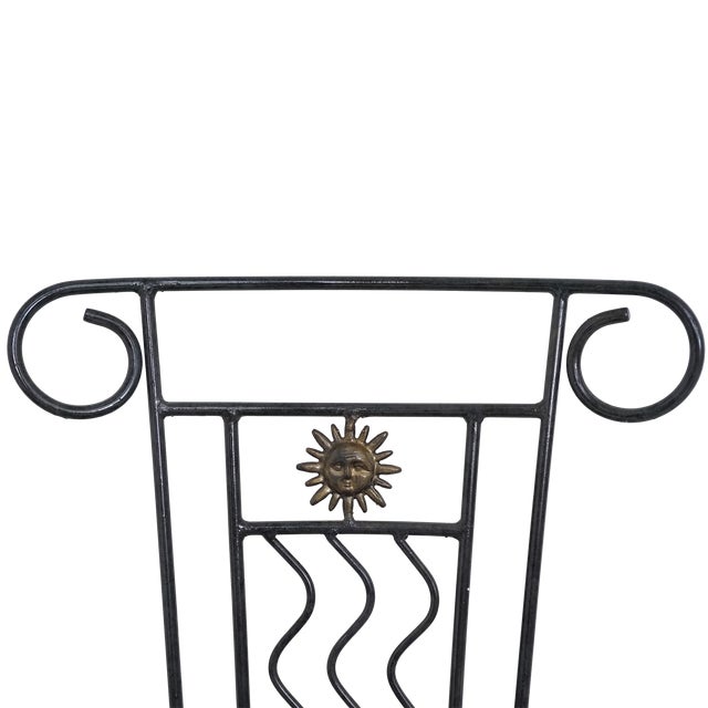 Wrought iron chairs from the mid-20th century. Scrolled details, sunburst medallions, and wavy back supports show clear...