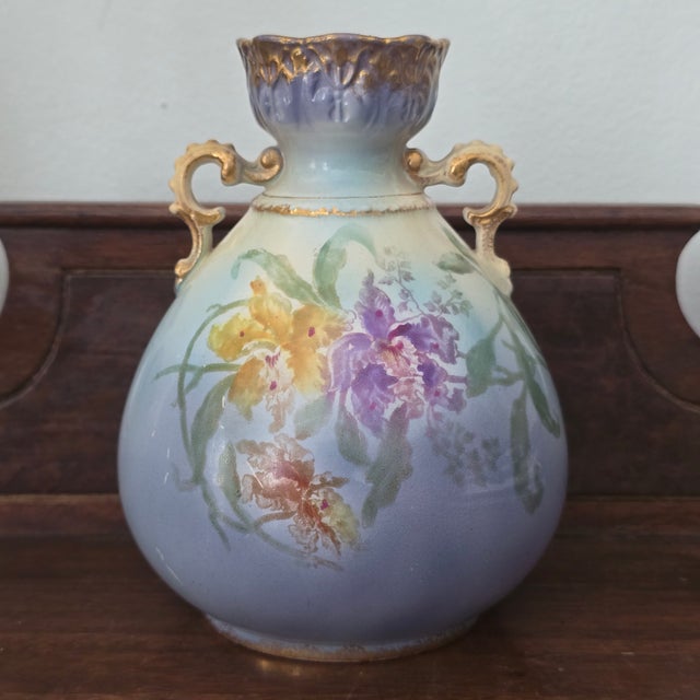 Beautiful 1885 Royal Bonn vase in blue with colorful orchids and gold accents.