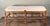 This vintage French country style wooden upholstered bench features a long rectangular seat in neutral linen fabric over a...