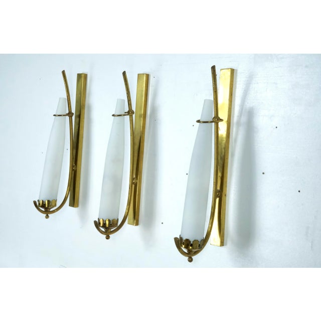 Set of three sconces in brass and triplex opaline glass, manufactured in Italy in the manner of Arredoluce Monza. Original...