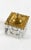 A square-cut crystal inkwell with thick, faceted glass walls, cylindrical well, gilt brass hinged lid with a pierced,...