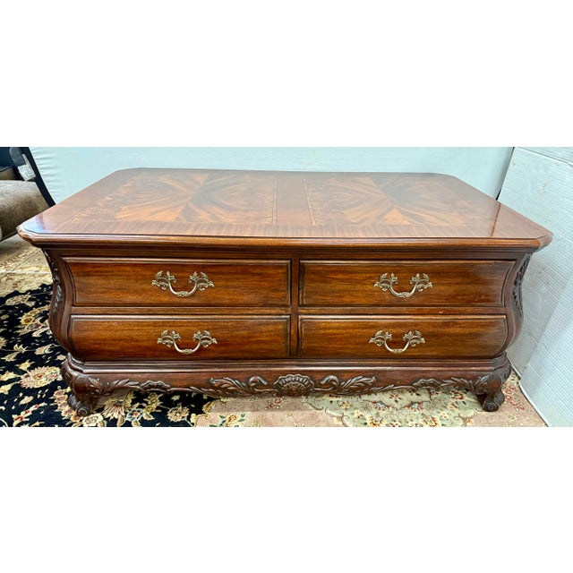 Classic Councill mahogany coffee table with elegant serpentine lines, carved apron, and cabriole-style feet. Eight...
