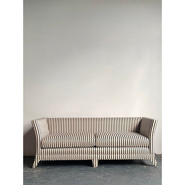 This striking vintage sofa is a masterclass in high-contrast design, featuring a bold black and white vertical stripe...