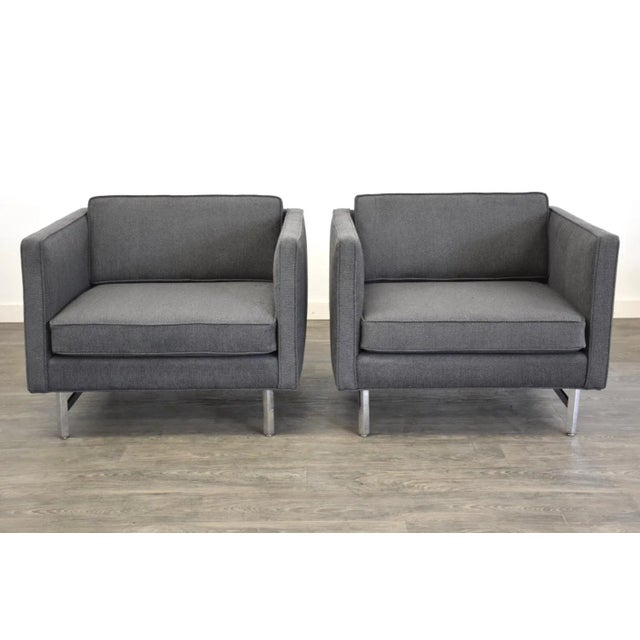 A pair of mid century modern grey cube lounge chairs with polished chrome frames in the style of Milo Baughman. Seat...