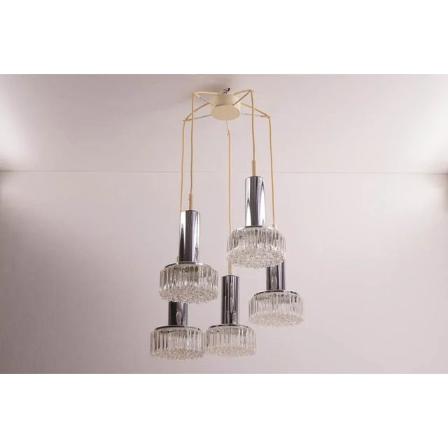 This mid-century cascade lamp was manufactured by Staff Leuchten and features chrome with textured glass pendants. The...