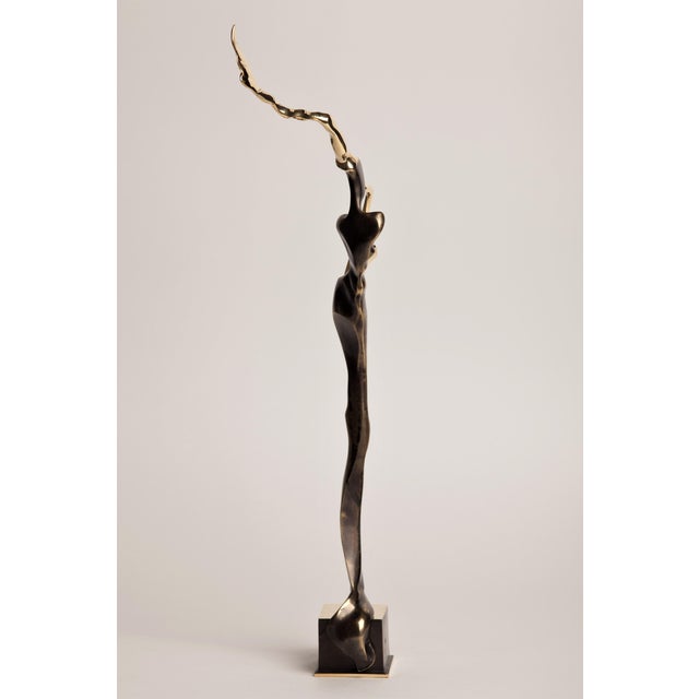 A contemporary figurative bronze of a woman playing the saxophone, her body abstracted into a single tall, twisting ribbon...