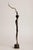 A contemporary figurative bronze of a woman playing the saxophone, her body abstracted into a single tall, twisting ribbon...