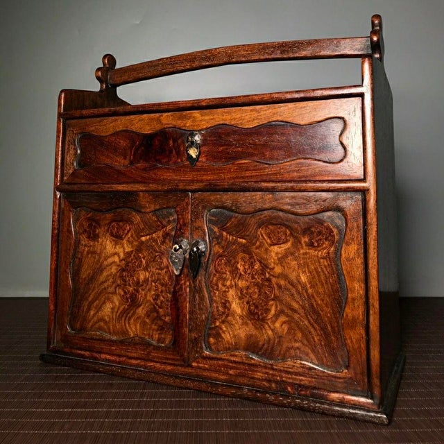 Exquisite portable rosewood cabinet fitted with a sturdy overhead carry handle. The front displays spectacular burl wood...