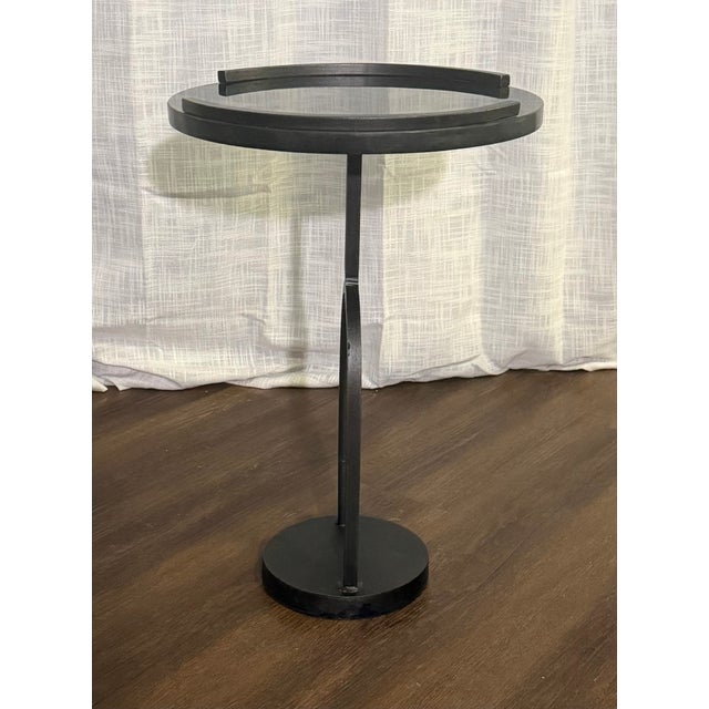 A sculptural Wishbone Accent Table from Studio A by Global Views, featuring a forged iron base and inset black granite...