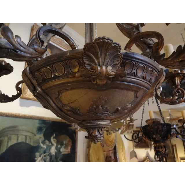 This is a six iron arms with tole bobeches ( US wired ) carved wood chandelier from France . Acanthus leaf design on the...