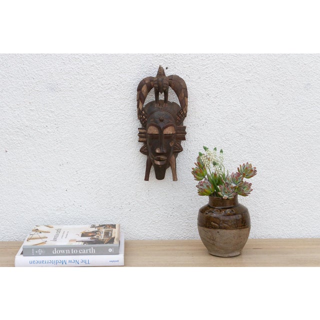 This striking mask, with its bold geometric patterns and avian-inspired design, speaks of a rich cultural heritage and...