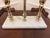 Striking three-candle candelabra featuring sculptural brass candleholders mounted on a substantial rectangular white...