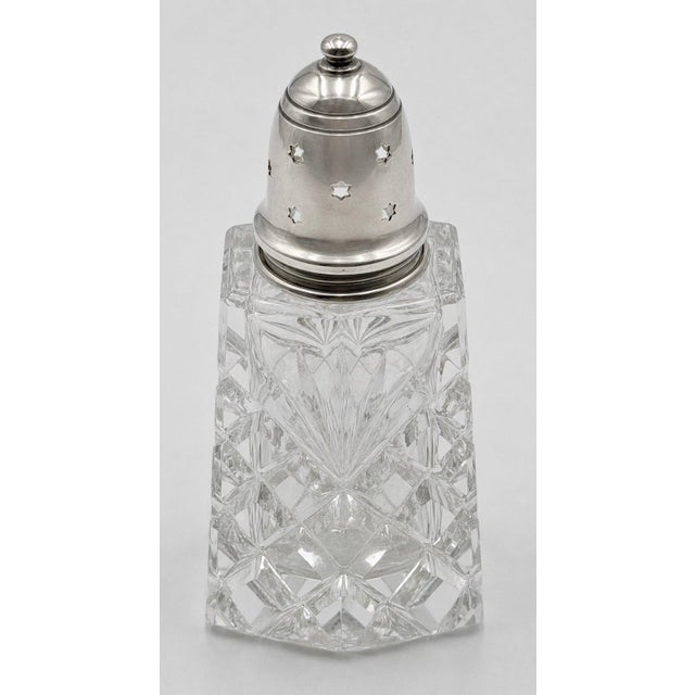 An English Edwardian sterling-silver and cut-glass muffineer or sugar caster, fully hallmarked for London, 1911. Its...