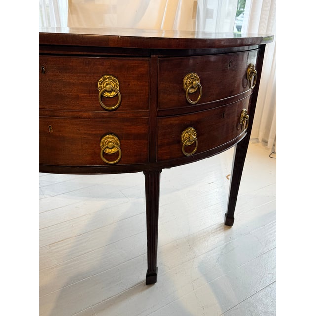 English Mahogany Demiluned Sideboard with Lion’s Head Brass Hardware, circa 1810 A handsome English Regency mahogany...