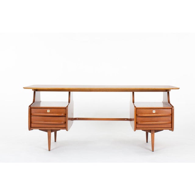 Elevate your interior with this exquisite mahogany desk by Jacques Hauville, designed in the 1950s and produced by the...