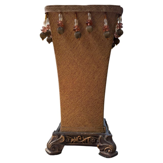 A warm and wonderfully theatrical vintage table lamp featuring a glowing amber-toned rectangular shade, cascading bead...