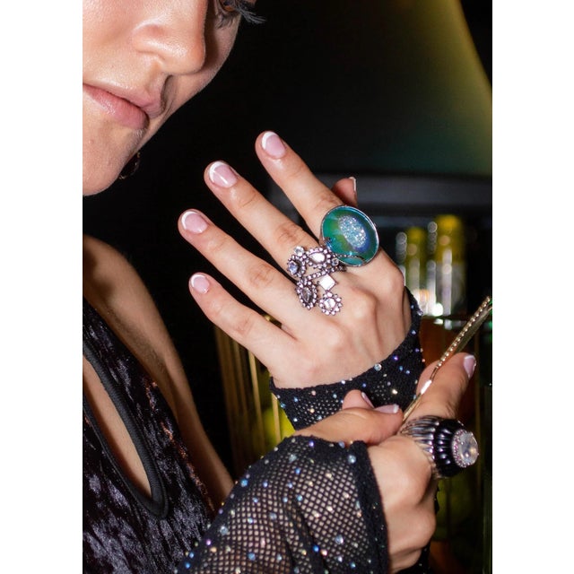 The Blue Crush Calcite Cocktail Ring features a natural calcite crystal with a PVD iridescent finish, mimicking the...