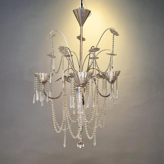 A beautiful rare chandelier with crystal details and silverplated metal base. Swedish neoclassicism, 1920s. In the manner...