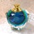 This is a clear faceted crystal perfume bottle with a blue and green bottle inside. The bottle has a metal neck with a...